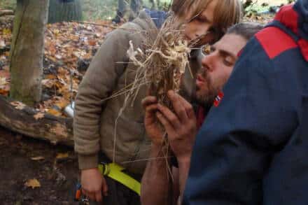 Mann und Kind machen Feuer im Wald.